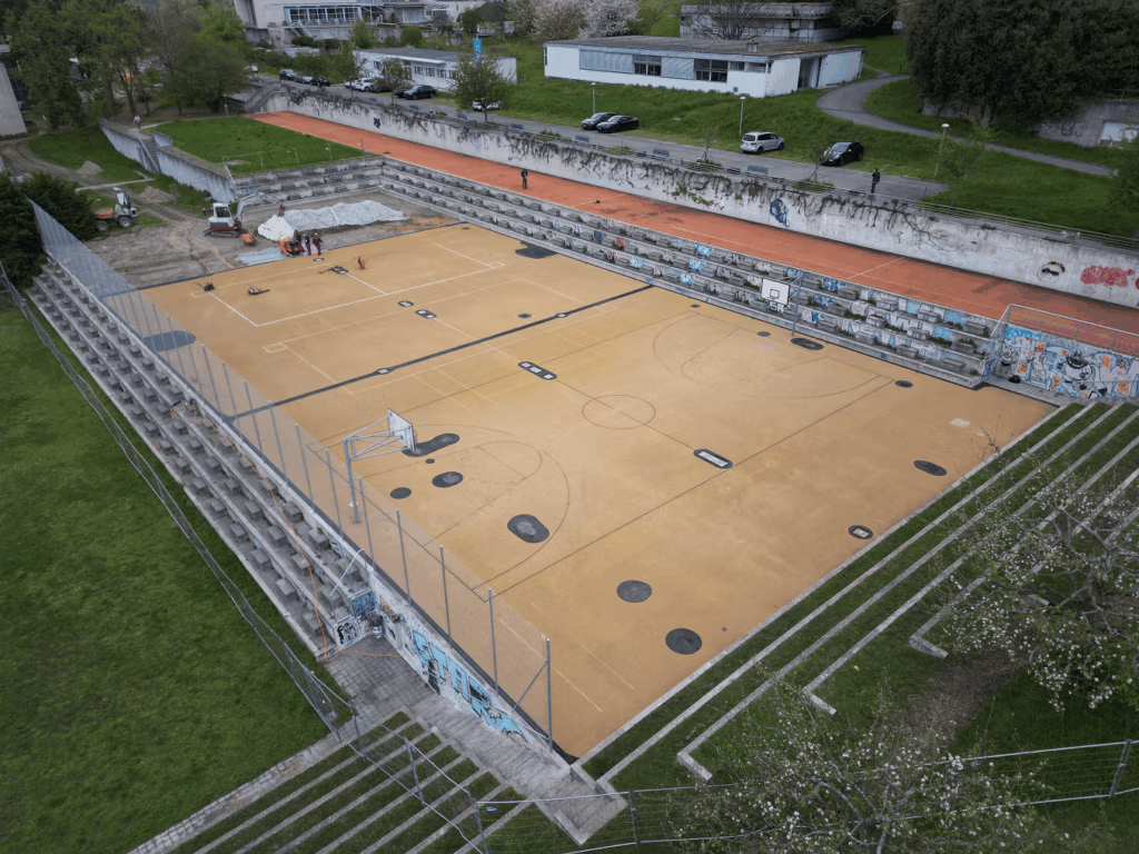 Préparation des zones à réfection sur terrain de multisport.