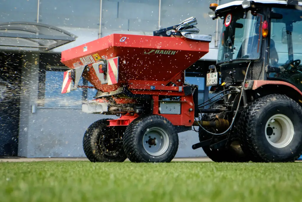 Epandage des engrais de printemps sur un terrain de football