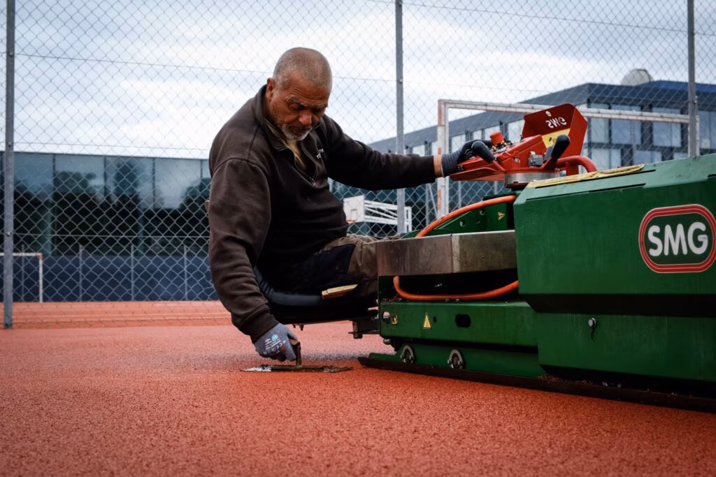 Collaborateur Terrasport entrain d'égaliser la couche de PU.