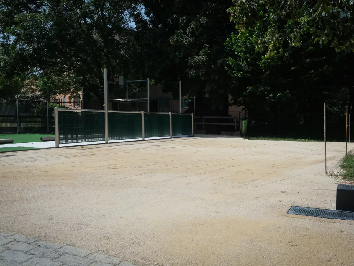 Premier tassement d'un espace en gravier pour des terrains de pétanque et l'aménagement de l'aire de jeu.