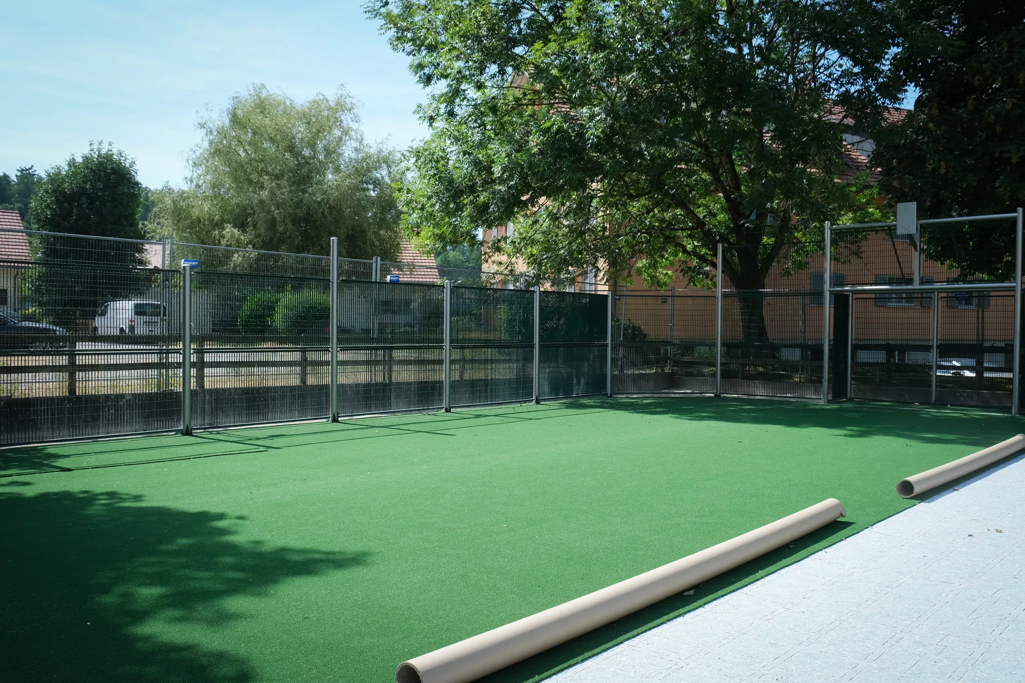 Revêtement en gazon synthétique à brin court, sur une installation d'un terrain multisport avec une structure de mini-stade.