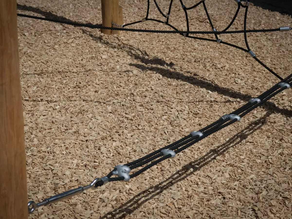 Éléments de jeu posés sur une surface en copeaux de bois pour amortir le corp à la chute et éviter les blessures.