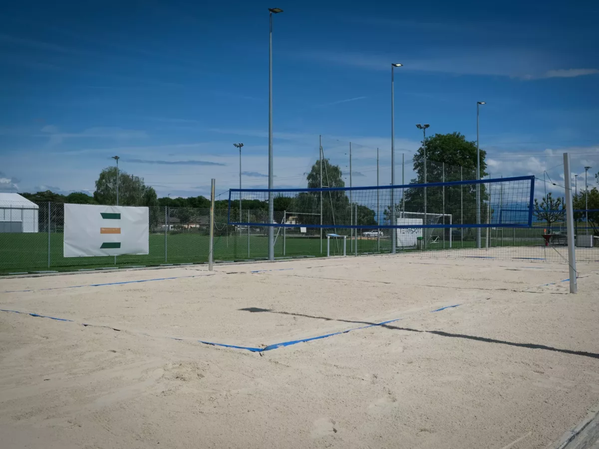 Entretien de la surface en sable et des équipements sportifs sur une installation de beach-volley.